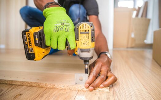 person using dewalt cordless impact driver on brown board